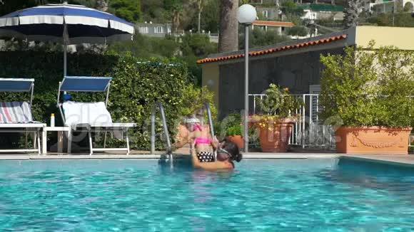 热带度假村游泳池的母亲和女儿视频的预览图