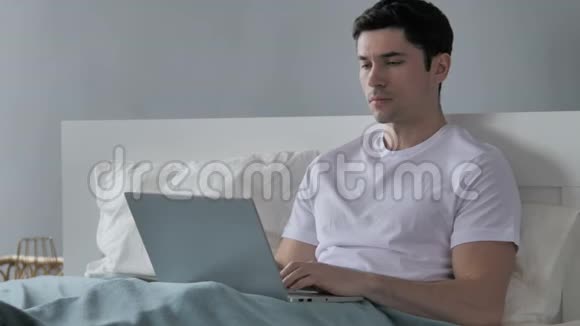 有脊背疼痛的年轻人坐在床上视频的预览图