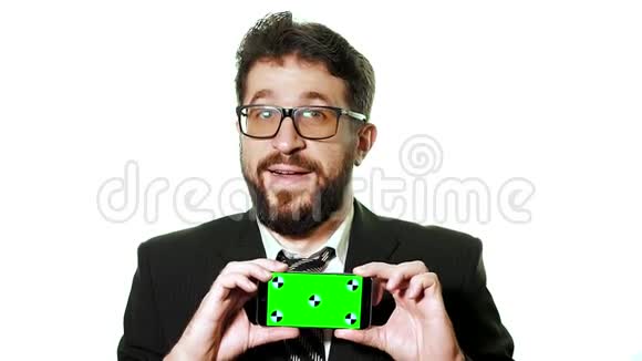 一个概念模型一个长胡子的商人戴着眼镜拿着一部智能手机上面有绿色屏幕作为名片视频的预览图