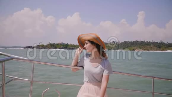 美丽的中镜头肖像快乐的年轻美丽的旅游妇女戴着太阳帽在海上游艇航行在游轮上视频的预览图