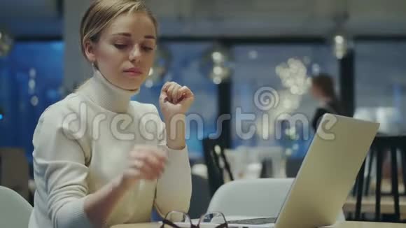 像作家一样的女孩戴上眼镜开始在笔记本电脑上工作视频的预览图