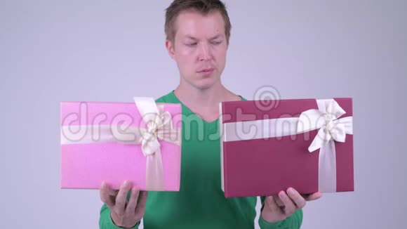 情人节快乐的年轻帅哥有两个礼品盒准备视频的预览图