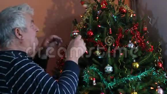 老人装饰圣诞树视频的预览图