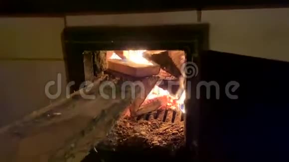 人的手在火焰的背景下向炉子里扔柴视频的预览图