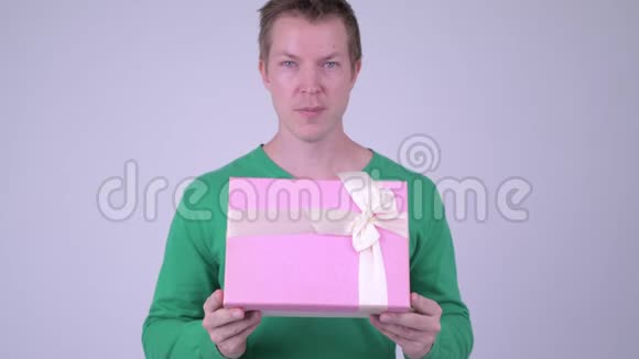 情人节快乐的年轻帅哥带着礼品盒准备视频的预览图