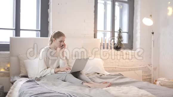 愤怒的女孩坐在床上打电话打架视频的预览图