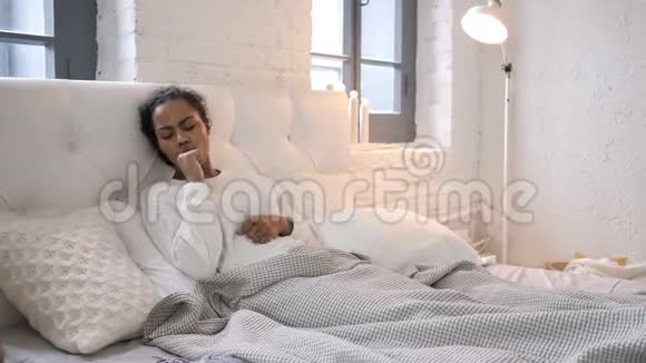 生病的非洲少女在床上放松时咳嗽视频的预览图