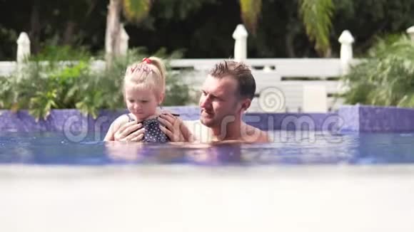 爸爸和他的小女儿在游泳池里游泳视频的预览图