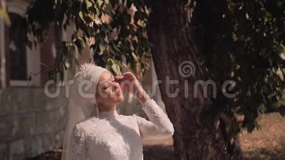 一个穿着白色连衣裙的漂亮女孩沐浴在美丽的阳光下令人惊叹的时尚框架视频的预览图