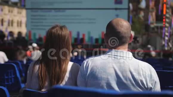 可爱的夫妇坐在市中心的蓝色椅子上坐在会议上听讲座盖盖视频的预览图