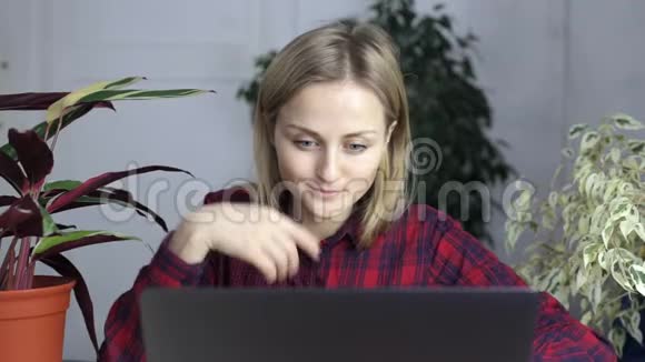 坐在房间笔记本电脑前看书的女孩视频的预览图