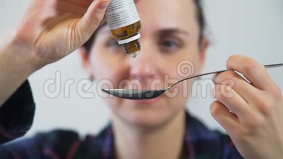 女人把药瓶里的药滴到勺子里视频的预览图