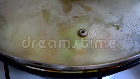 成熟的女人在厨房做饭蔬菜在锅里炒洋葱西葫芦胡萝卜视频的预览图