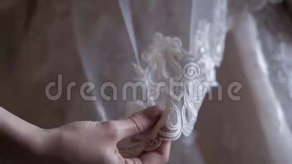 一个女人的手正一件婚纱视频的预览图