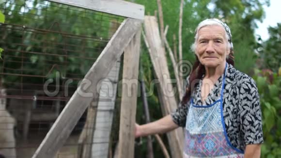 一位老妇人向谷仓打开一扇木门第三世界国家贫穷的农村生活视频的预览图