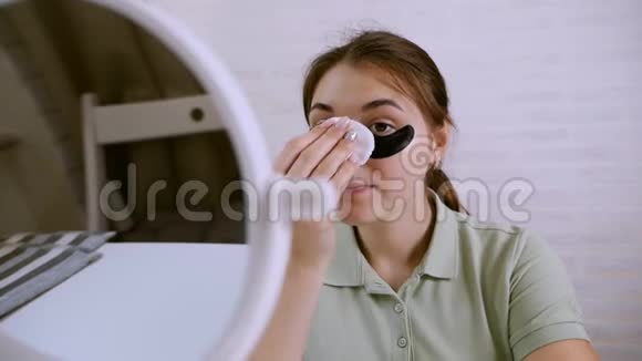 美丽的年轻女人在眼睛周围做皮肤护理护肤理念女孩用棉签清洁皮肤视频的预览图