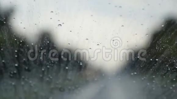 雨滴滴下了汽车在路上的挡风玻璃视频的预览图