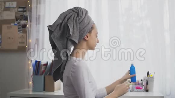 年轻女子在毛巾上用头发喷雾视频的预览图