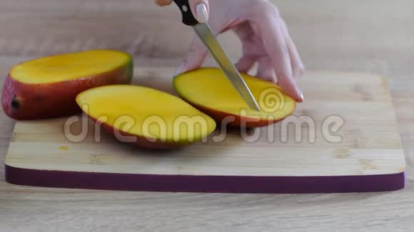 女厨师她的手在木切割板上切芒果视频的预览图