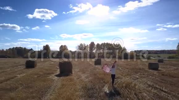 漂亮的上景女人走在田里的草卷里视频的预览图