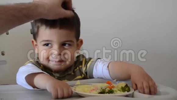 父亲抱着一个脾气暴躁的两岁男孩他拒绝吃饭视频的预览图