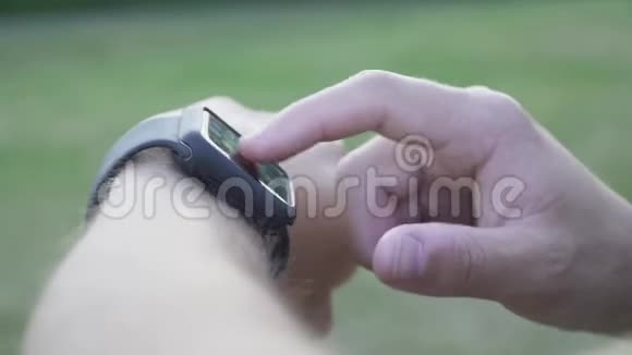 年轻人通过蓝牙技术控制智能手机上的智能手表视频的预览图