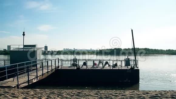 人们男人和女人在美丽的一天在海滩上做运动组的男女生训练健身小组视频的预览图