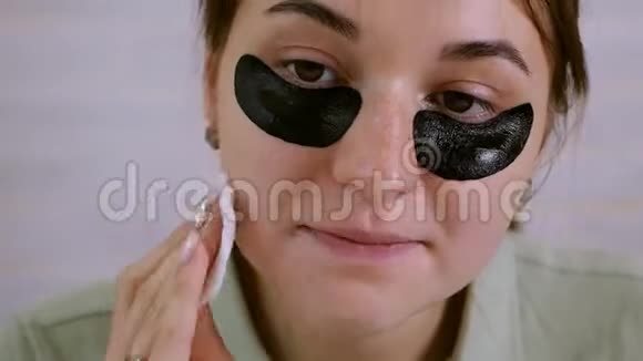 美丽的年轻女人在眼睛周围做皮肤护理皮肤护理概念女孩用棉签清洁皮肤视频的预览图