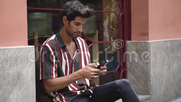 年轻人用智能手机坐在城市台阶上视频的预览图