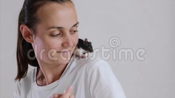 坐在她肩膀上的年轻女人和宠物老鼠正在一起吃早餐视频的预览图
