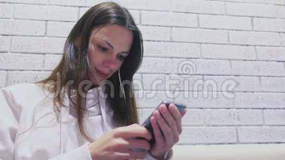 女人正在手机上输入一条信息坐在咖啡馆里等人侧视视频的预览图