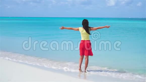 美丽的年轻女子在海滩上浅水区散步慢动作录像视频的预览图
