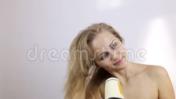 年轻女子洗完澡后用吹风机擦干头发视频的预览图