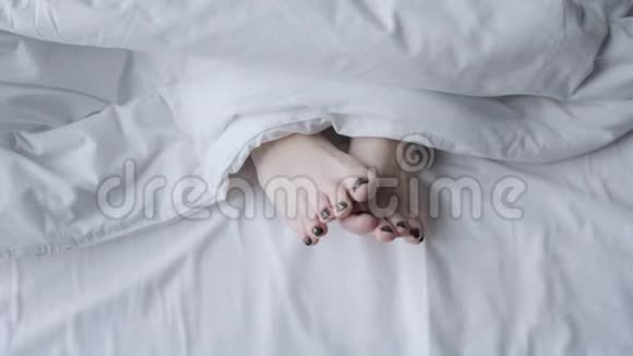 年轻的妇女站在白色的毯子下面健康护理理念早上在酒店房间视频的预览图