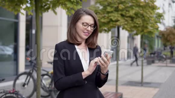 内容优雅的女人使用电话在城市街道视频的预览图