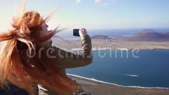 快乐女游客用智能手机拍摄美丽的岛屿景观视频视频的预览图