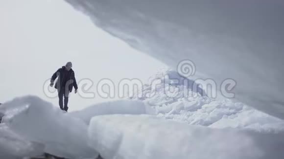 在冰川上行走的背景上孤独的男性游客令人惊叹的雪景北极或南极冰视频的预览图