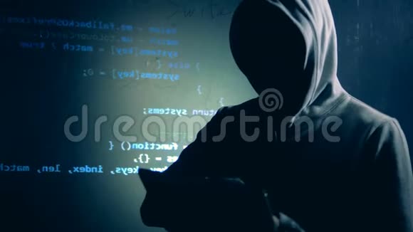 伪装的黑客正在操作一个平板电脑旁边的墙上有投影数据视频的预览图
