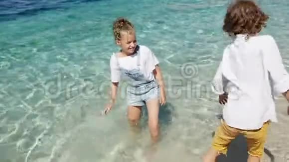 孩子们在户外的水里玩得很开心快乐的孩子快乐的小男孩和女孩在浅水中玩耍夏日乐趣视频的预览图