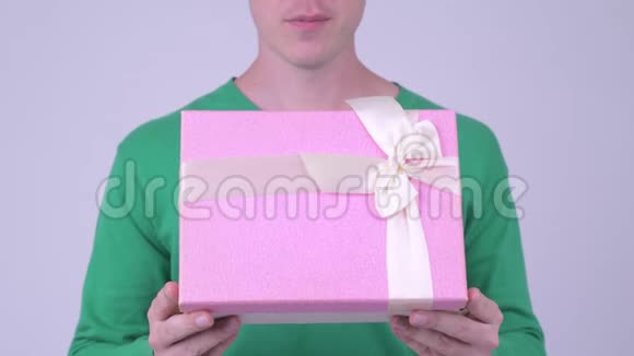 情人节快乐的年轻帅哥带着礼品盒准备视频的预览图