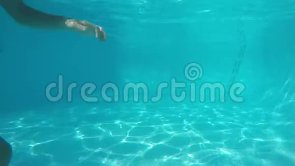 穿着蓝色泳衣的白人女孩在镜头前潜水泡泡从嘴里冒出来从水池下看视频的预览图