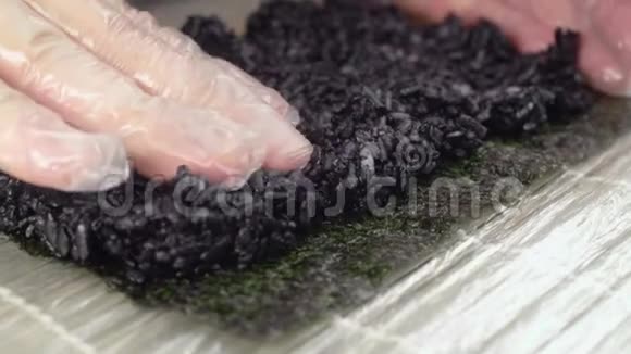 厨师把黑米放在诺里上慢慢做寿司卷烹饪亚洲食物寿司和黑米过程视频的预览图