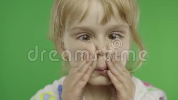 漂亮的孩子用她的眼睛做疯狂的脸肖像色度键视频的预览图