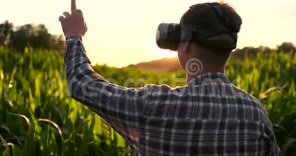智能农业与物联网未来农业概念农民戴VR或AR眼镜同时监测降雨视频的预览图