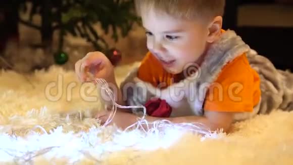 孩子在孩子们房间里玩圣诞灯花环快乐的童年视频的预览图