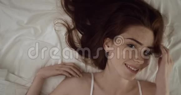 美女在床上拍照的俯视图视频的预览图