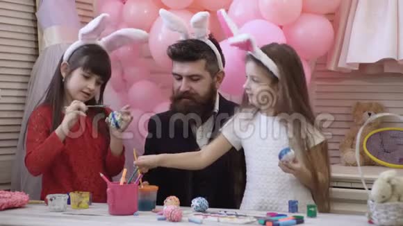 爸爸和他的小女儿在准备复活节假期时一起玩得很开心桌子上有一个带复活节的篮子视频的预览图