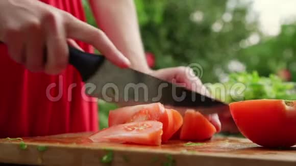 女士手准备新鲜蔬菜沙拉切熟番茄视频的预览图