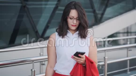 穿着紧身衣的年轻女性使用智能手机视频的预览图