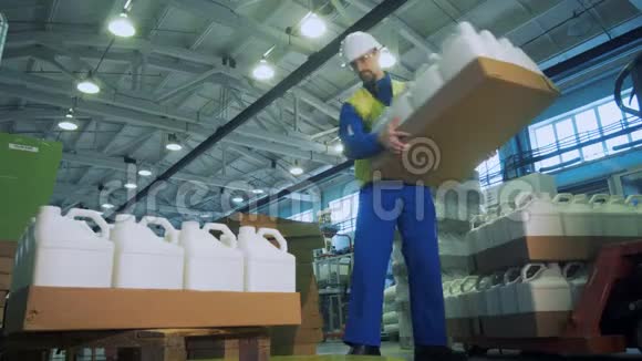 工业工人用塑料罐把纸箱托盘堆放起来视频的预览图